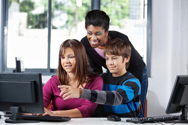 Boy and Girls Using Simple Wikipedia with Teacher