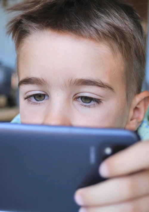 Close up of a boy eyes staring at a smartphone screen