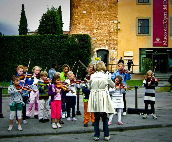 Group of Kids playing voilins outside.