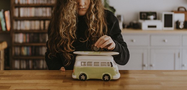 Girl Saving Money in Piggy Bank