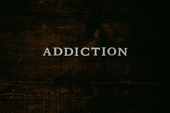 Word ADDICTION written on a dark background