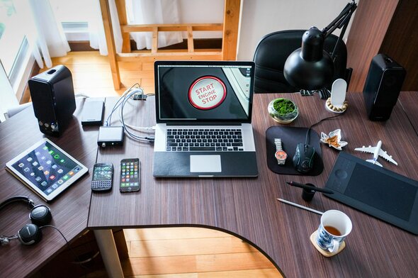 Various tech devices, including tablets and phones, on an office table.