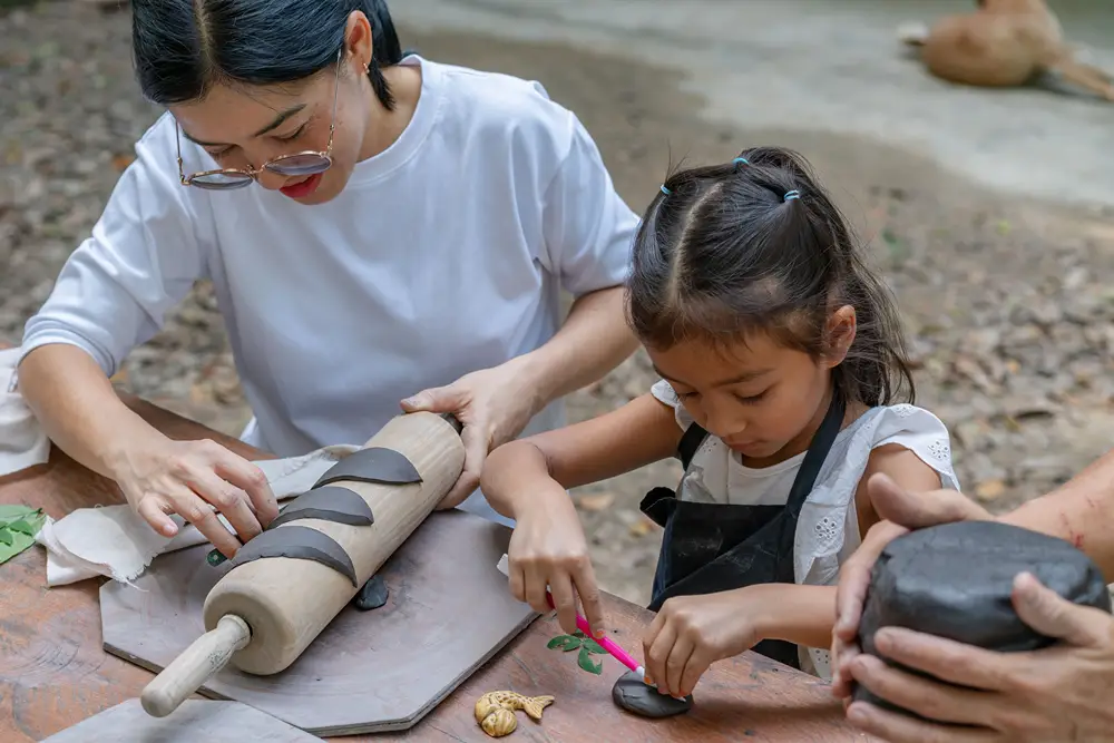 Mom and daughter creating something with clay.