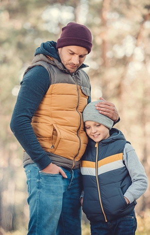 Father and son dressed for cool weather outdoors.