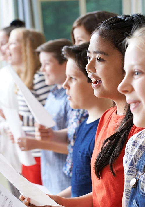 A row of kids singing in music classroom.