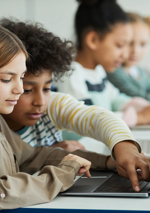 A girl and boy sharing a tablet in class at school.