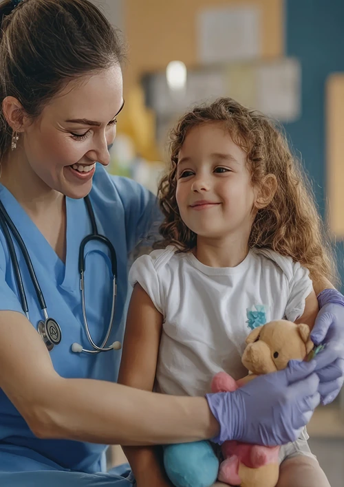 A little girl sits on a female nurse's lap.