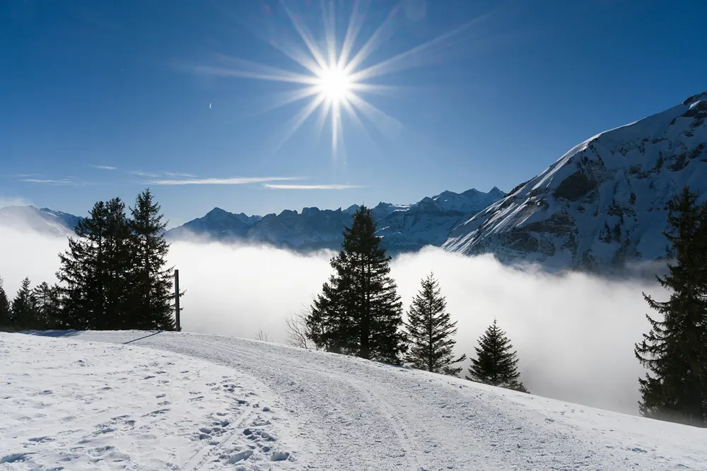 Diamond sun over the Swiss Alps on a clear day.