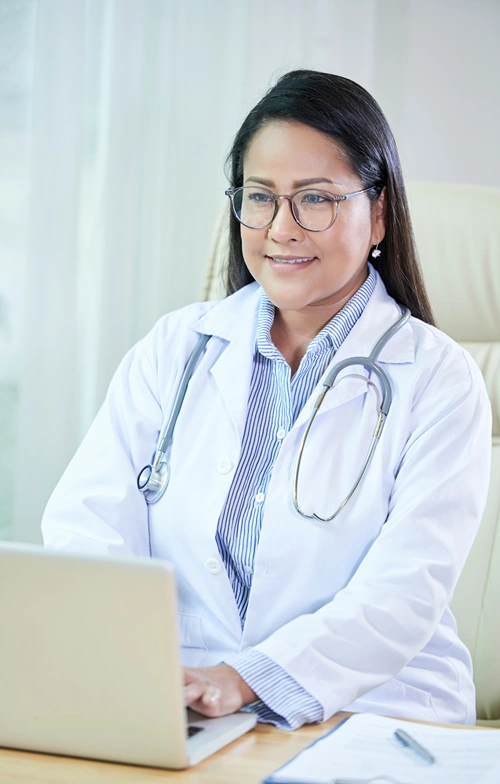 A doctor takes a patient appointment on her computer