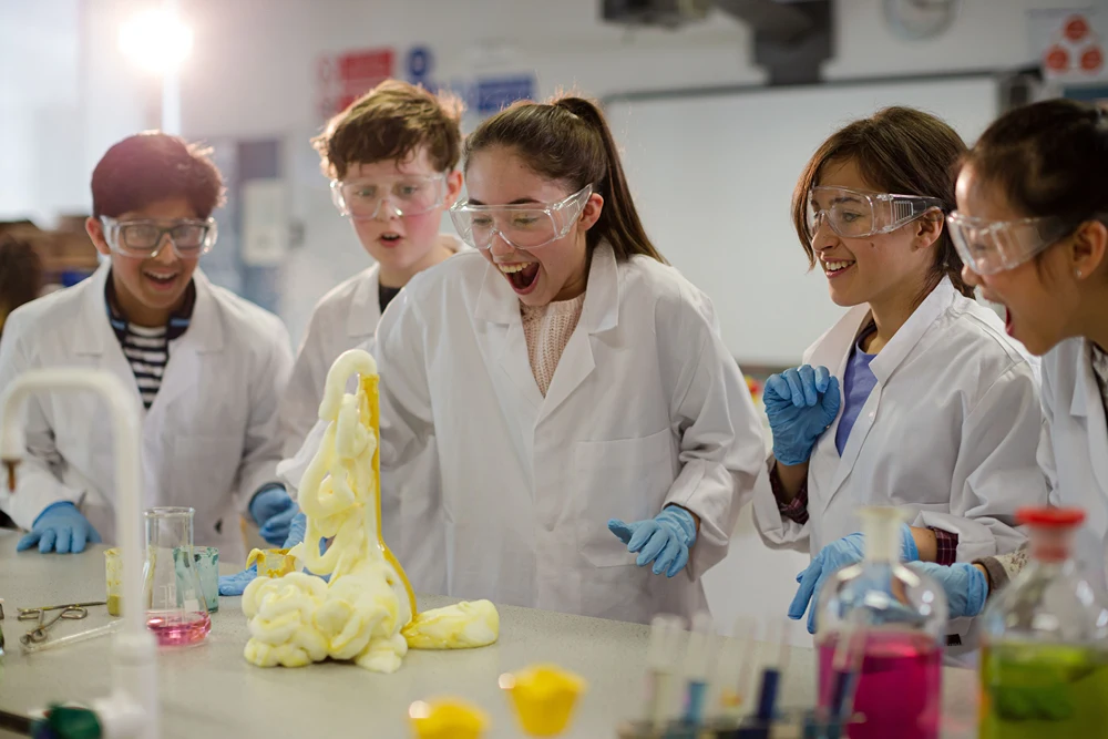 Middle school aged kids watching a chemical reaction in science lab.