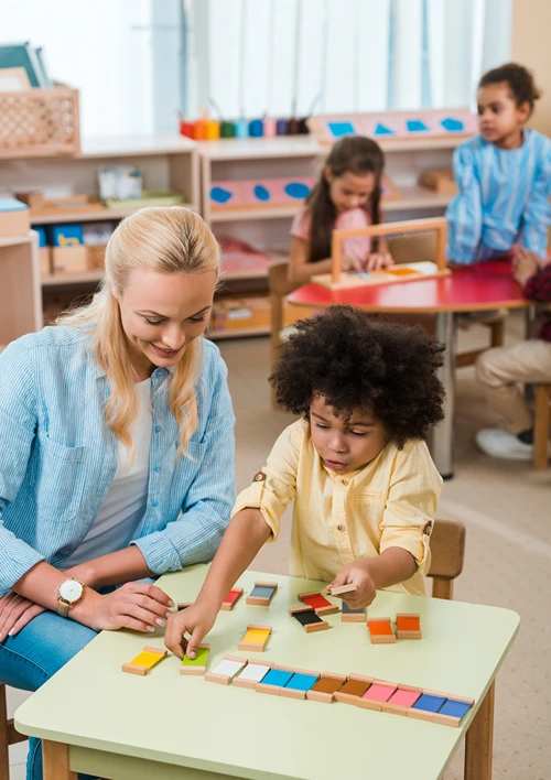 A your child is playing a colored block game with an adult supervisor.
