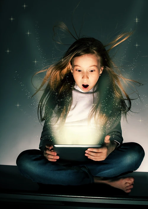 A tween girl with an astonished look at a bright tablet screen.