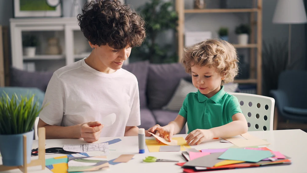 A mother and son doing paper crafts.