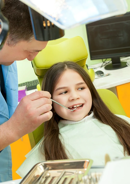 7 year old girl smiling in orthodontist chair.