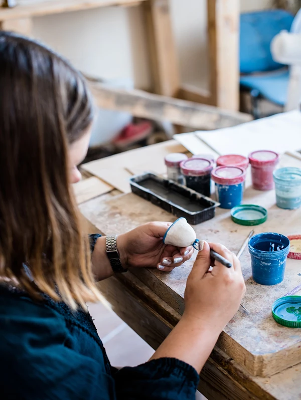 Girl painting a ceramic she made.