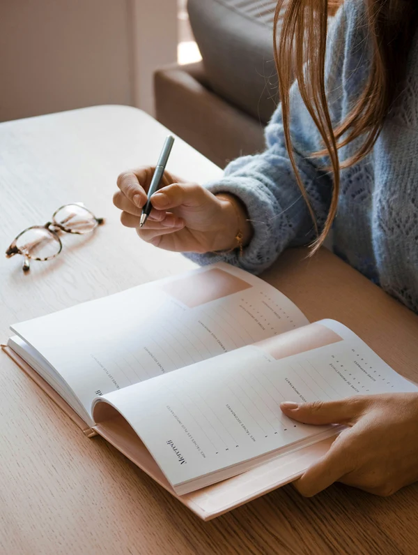 View from above of a girl writing in her student planner.