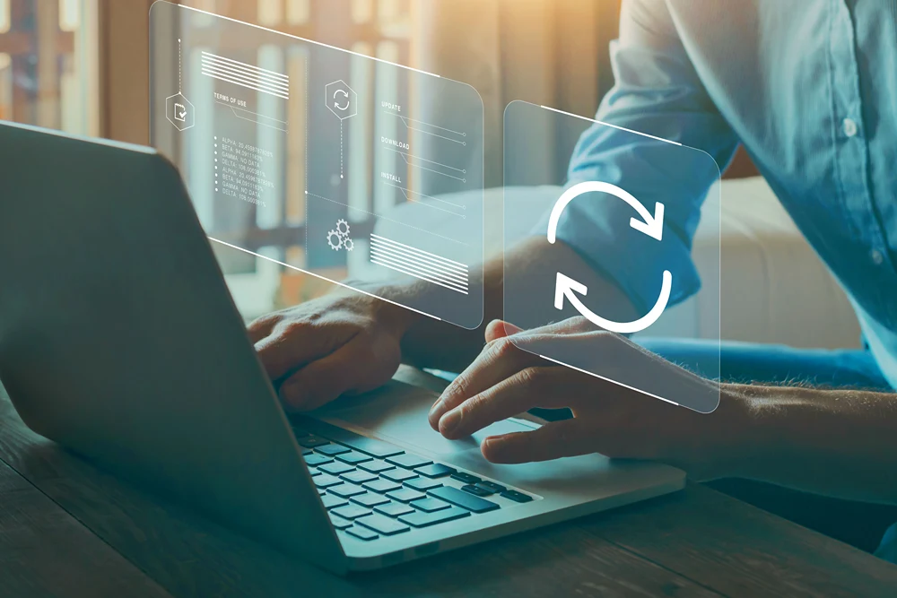 Man updated a computer as turning update symbol appears above.