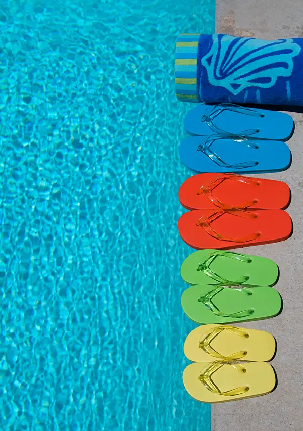 Flip Flops linked up by the edge of a public swimming pool.