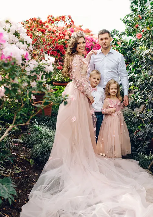 Mom on wedding dress with new husband and kids.