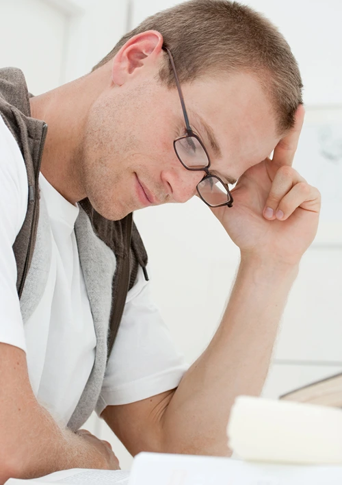 Male student learning on his hand while studying hard.