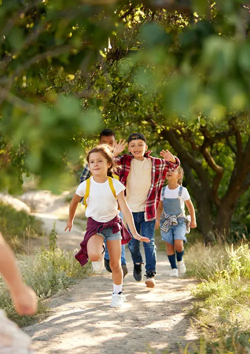 Group of kids running on a nature path outdoors.