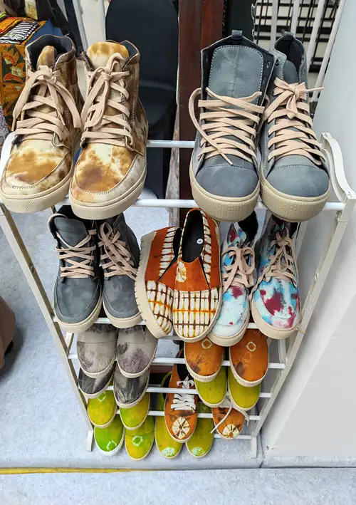 Dirty shoes stacked in a rock in home entrance way.
