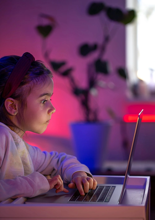 Curious young girl using a laptop.