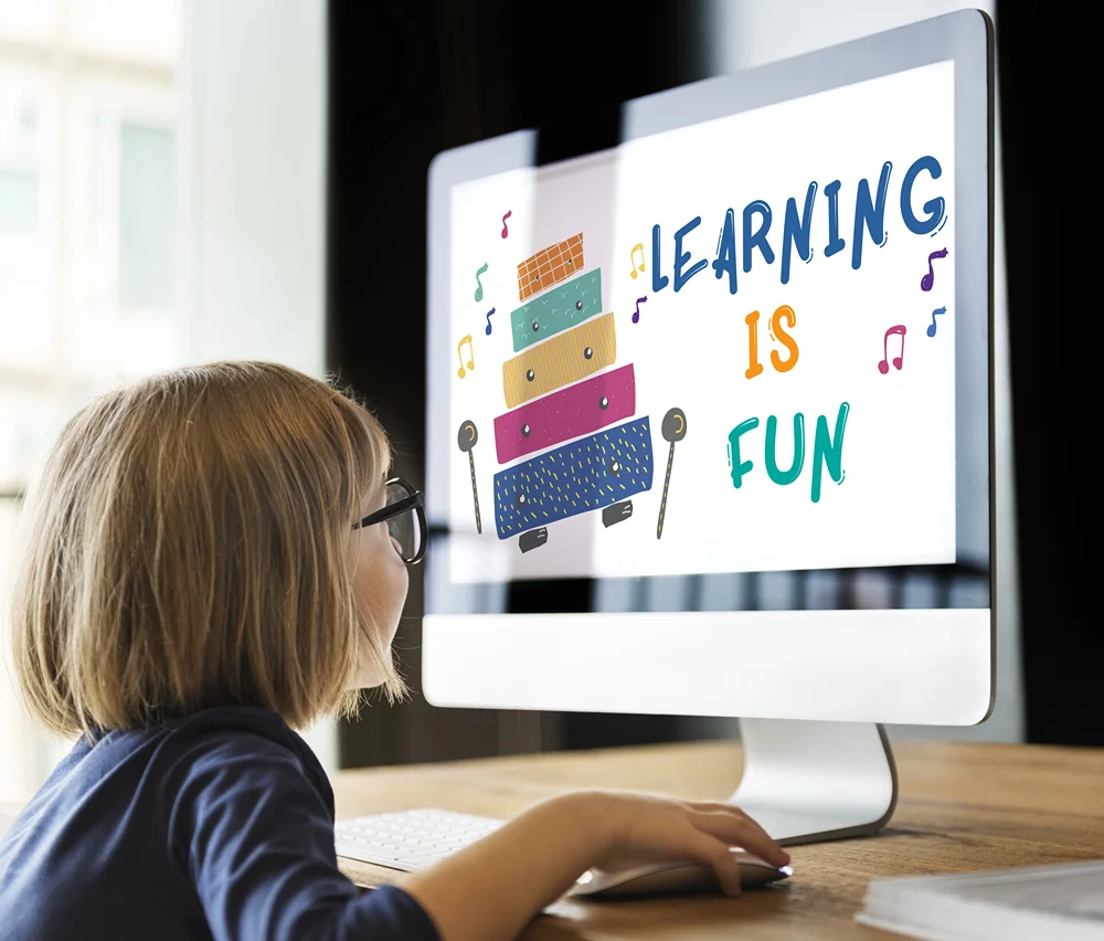 Small  child in front of large computer screen with mouse in hand.