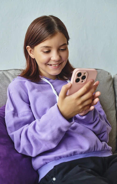 Teen girls engaged on her phone with friend on the other end.