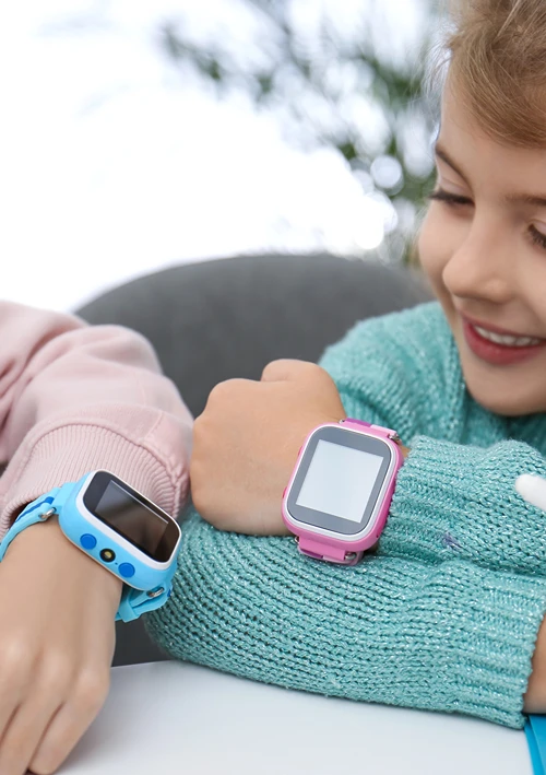 Two kids showing each other their smart watches.