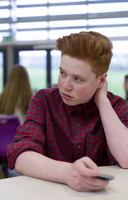 Concerned male student in classroom setting.