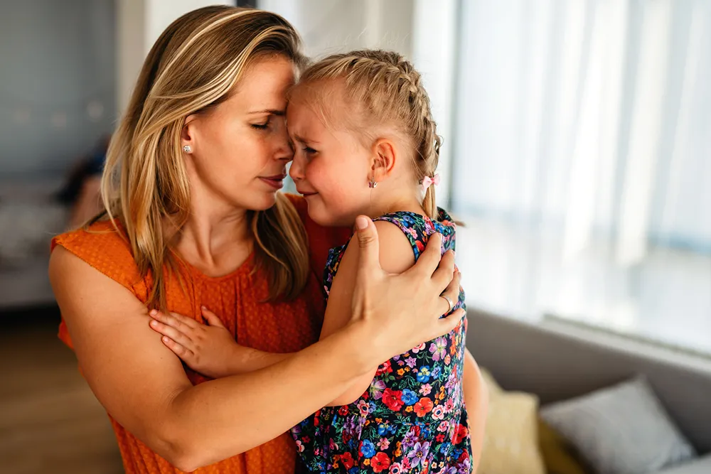 A mother comforts her crying daughter.