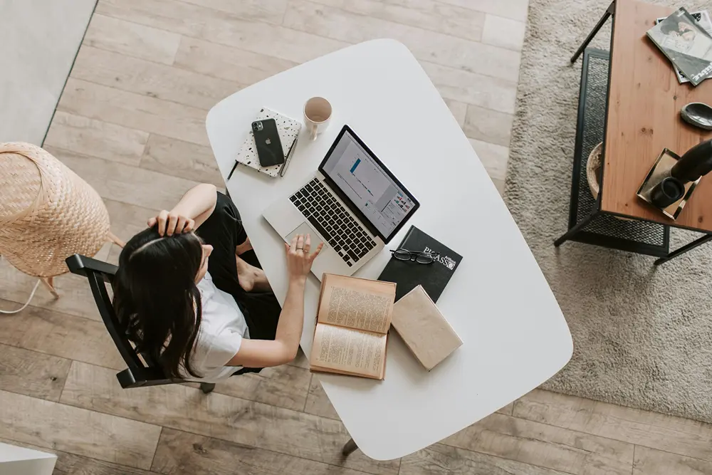 Young woman at desk working on her laptop.