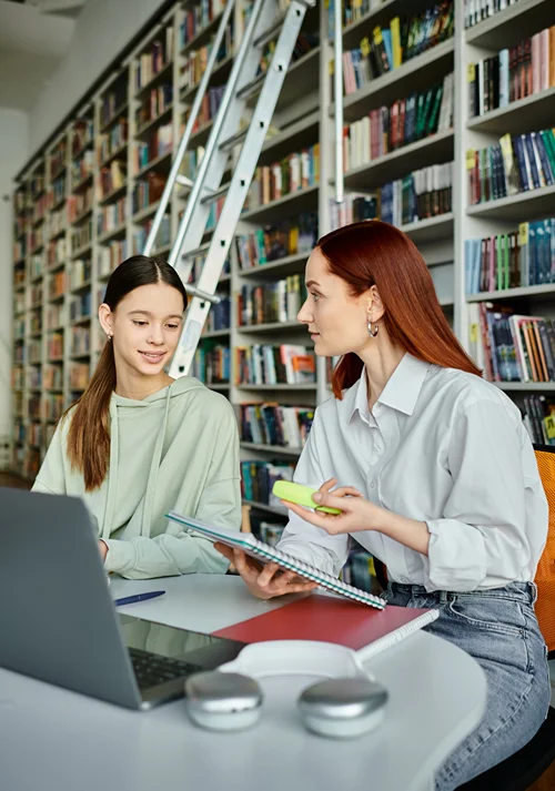 Middle school student with tutor in a library.