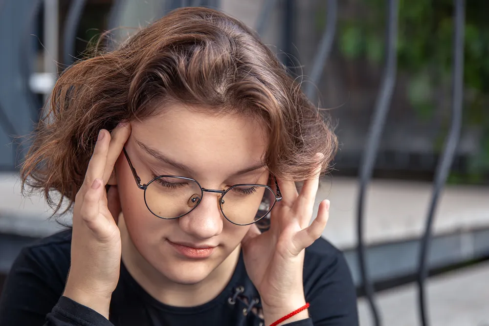 A young woman with fingers on her temples.