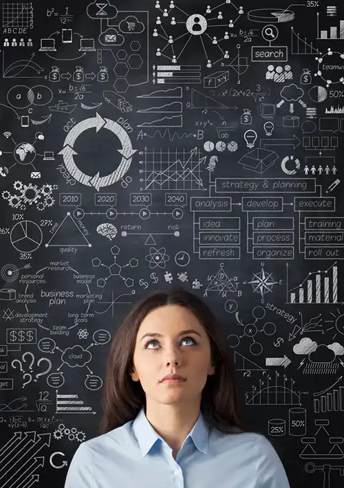A woman looks up considering multiple ideas presented on a blackboard.