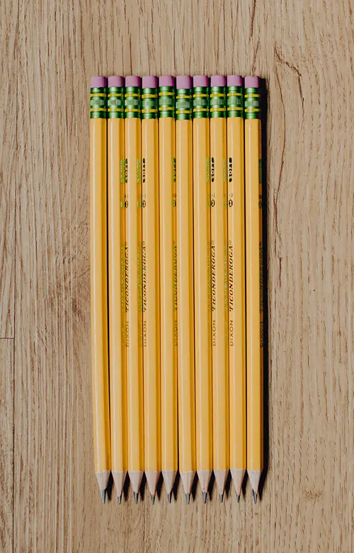 A row of pencils neatly laid out on a table.