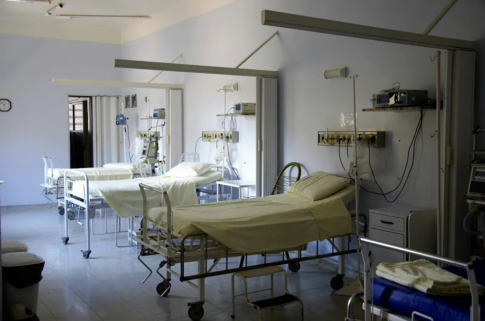 Empty beds in a communal hospital room.