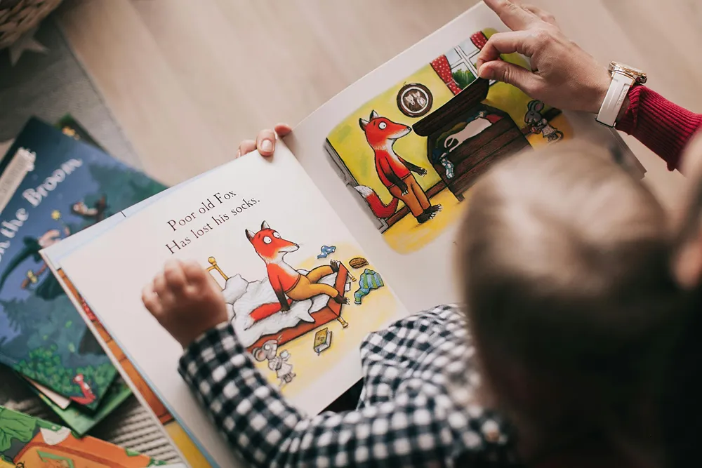 Look from above of a boy reading a storybook.