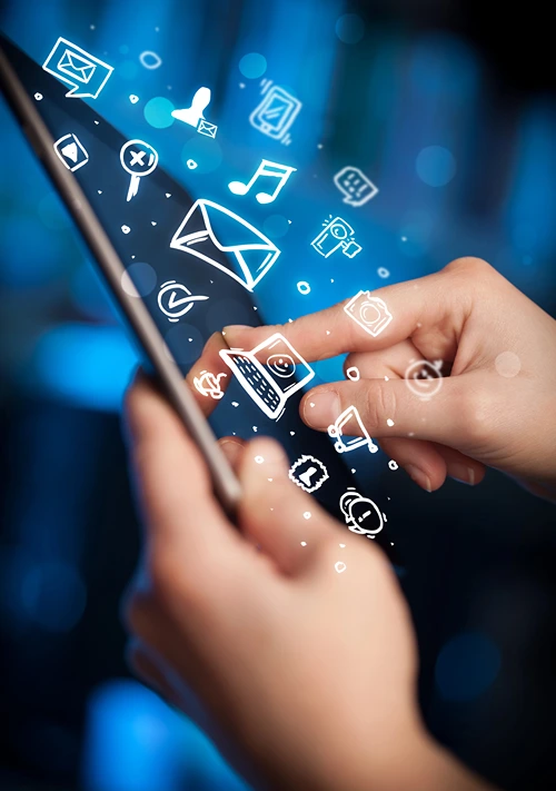 Close up of hands on a tablet with internet relate icons swirling above.
