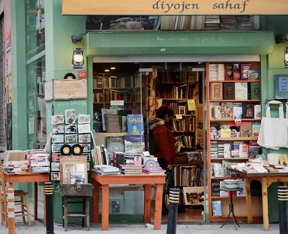 Book store with door open and tables of used books on the sidewalk.