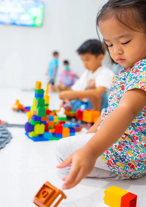 Kids playing on floor in classroom.