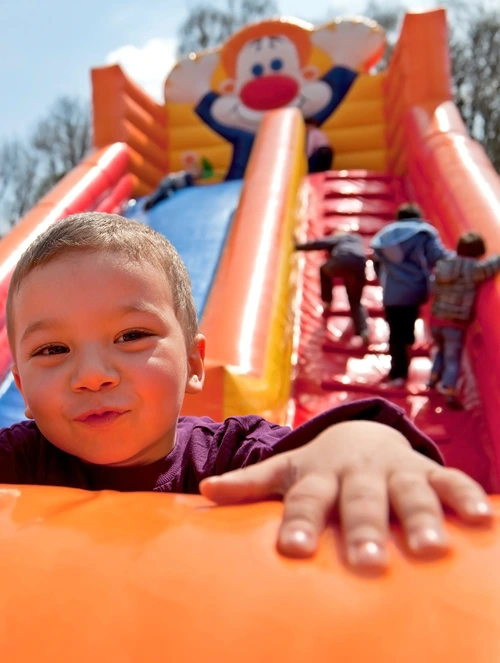 Kids playing on large inflatable bouncy slide.