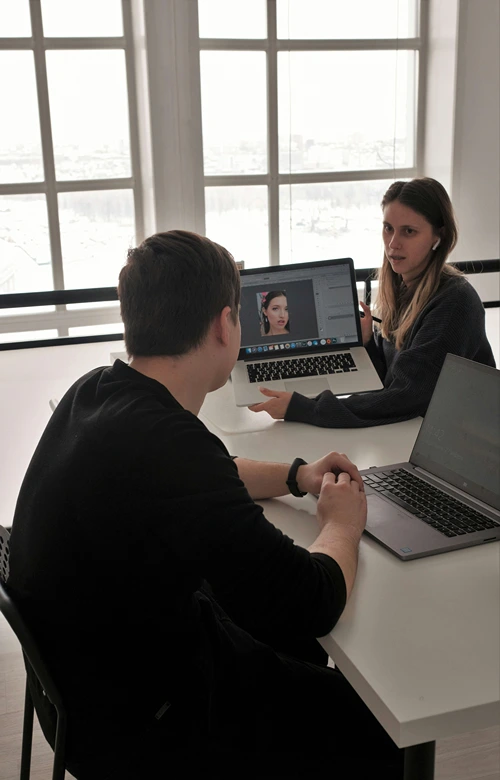 A therapist holding laptop with video in session with teen boy.