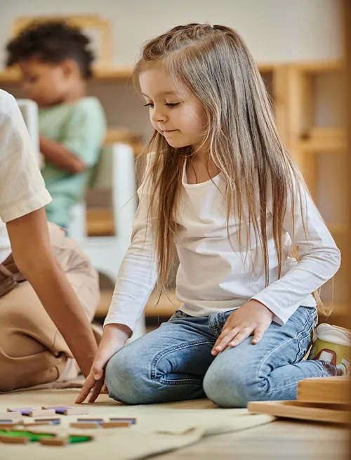 Children playing and learning together on the floor.