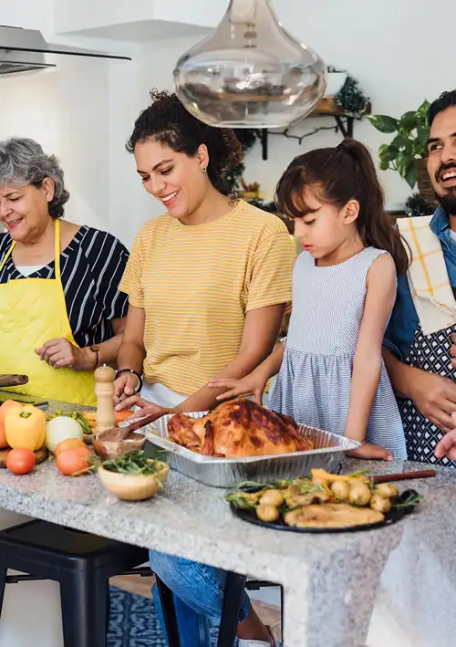 Family in the kitchen cooking meal together.