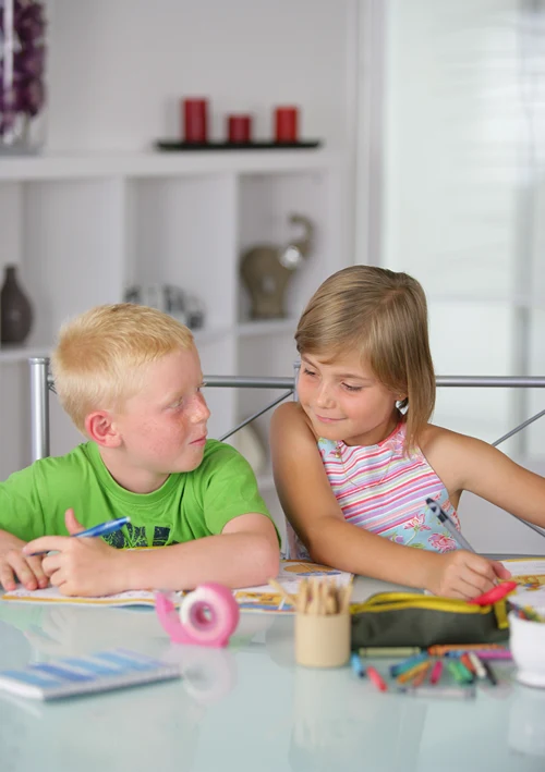 A boy and girl doing crafts together at home.
