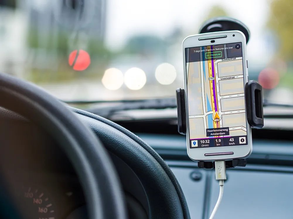 Smart phone with maps in a car dash holder.