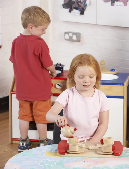 Girl and boy having fun in a play kitchen.