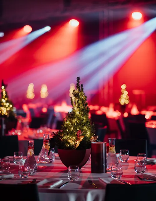 Table in fancy banquet hall with a Christmas tree as the centerpiece.